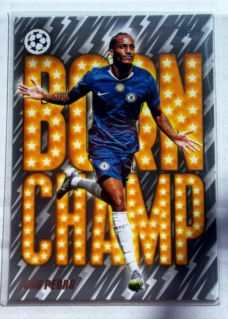 João Pedro, Topps UEFA Club Competitions 2025/26 Born Champ, karta BC-3 — awers z wielkim żółtym napisem BORN CHAMP w gwiazdki i piłkarzem w granatowym stroju Chelsea