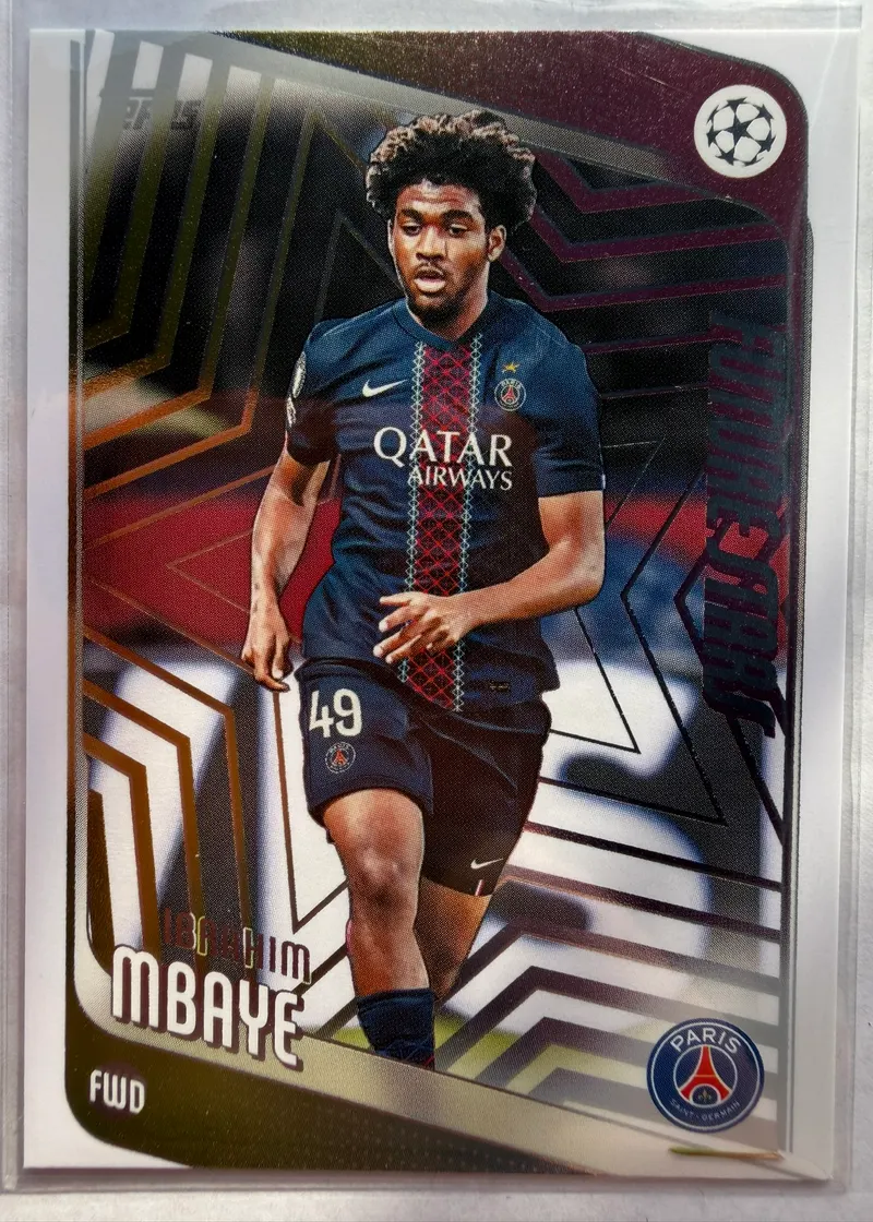 Ibrahim Mbaye, Topps UEFA Club Competitions 2025/26 Future Stars, karta 158 — awers ze złoto-bordową geometryczną grafiką i piłkarzem w stroju Paris Saint-Germain
