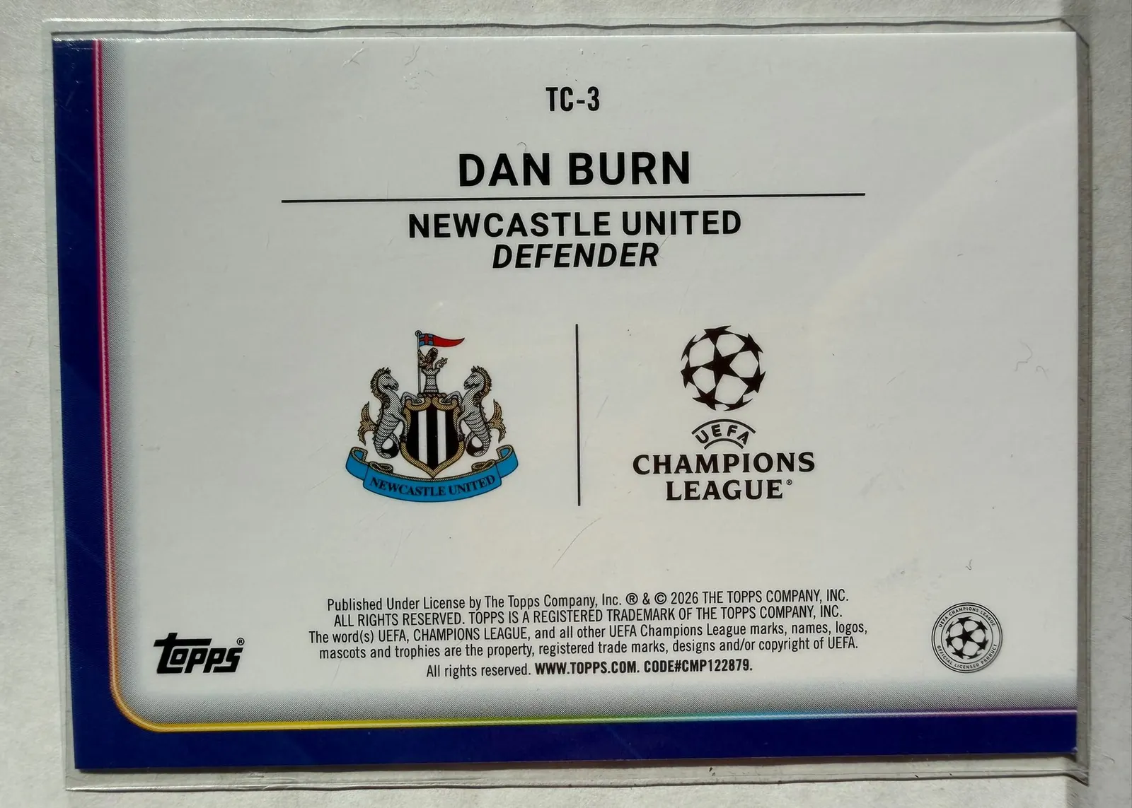 Dan Burn, Topps UEFA Club Competitions 2025/26, karta TC-3 — rewers z herbem Newcastle United i logo Ligi Mistrzów
