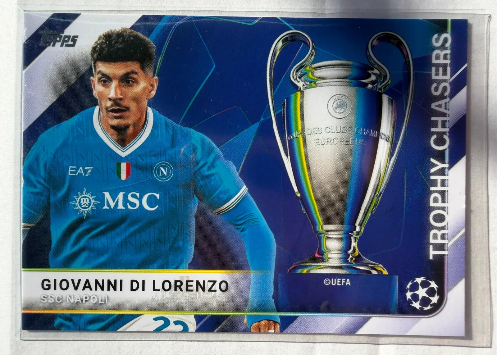 Giovanni Di Lorenzo, Topps UEFA Club Competitions 2025/26 Trophy Chasers, karta TC-18 — pozioma karta z pucharem Ligi Mistrzów i piłkarzem w błękitnym stroju Napoli