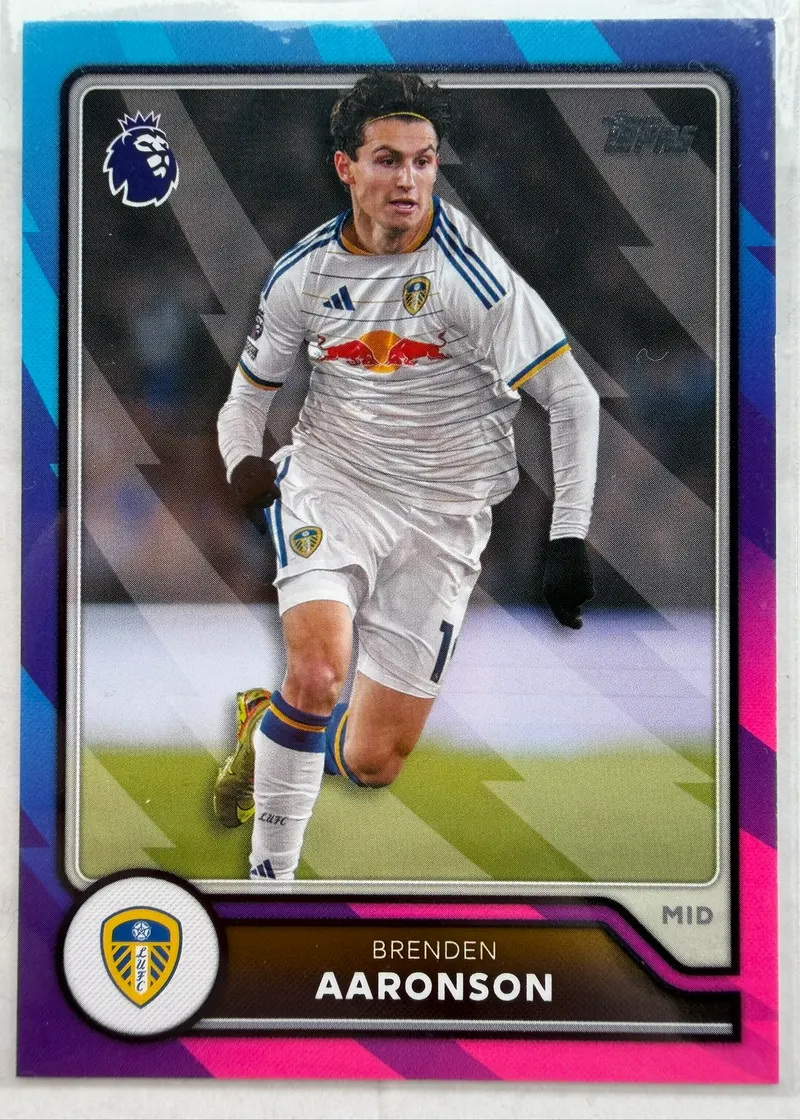 Brenden Aaronson, Topps Premier League 2026/27 nr 154 PL Parallel — awers z pomocnikiem Leeds w białym stroju, w ramce przechodzącej od turkusu przez granat do magenty