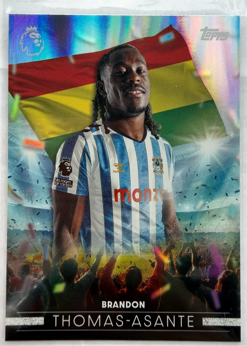Brandon Thomas-Asante, Topps Premier League 2026/27, insert Flying the Flag — awers z napastnikiem Coventry City w niebieskim stroju na tle ghańskiej flagi