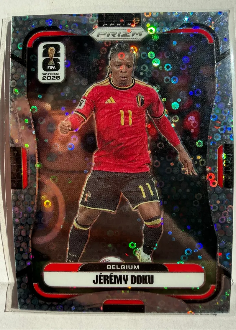 Jérémy Doku, Panini Prizm FIFA World Cup 2026 Disco Prizm, karta 152 — awers z tłem w tęczowe kółka i piłkarzem w czerwonym stroju reprezentacji Belgii z numerem 11