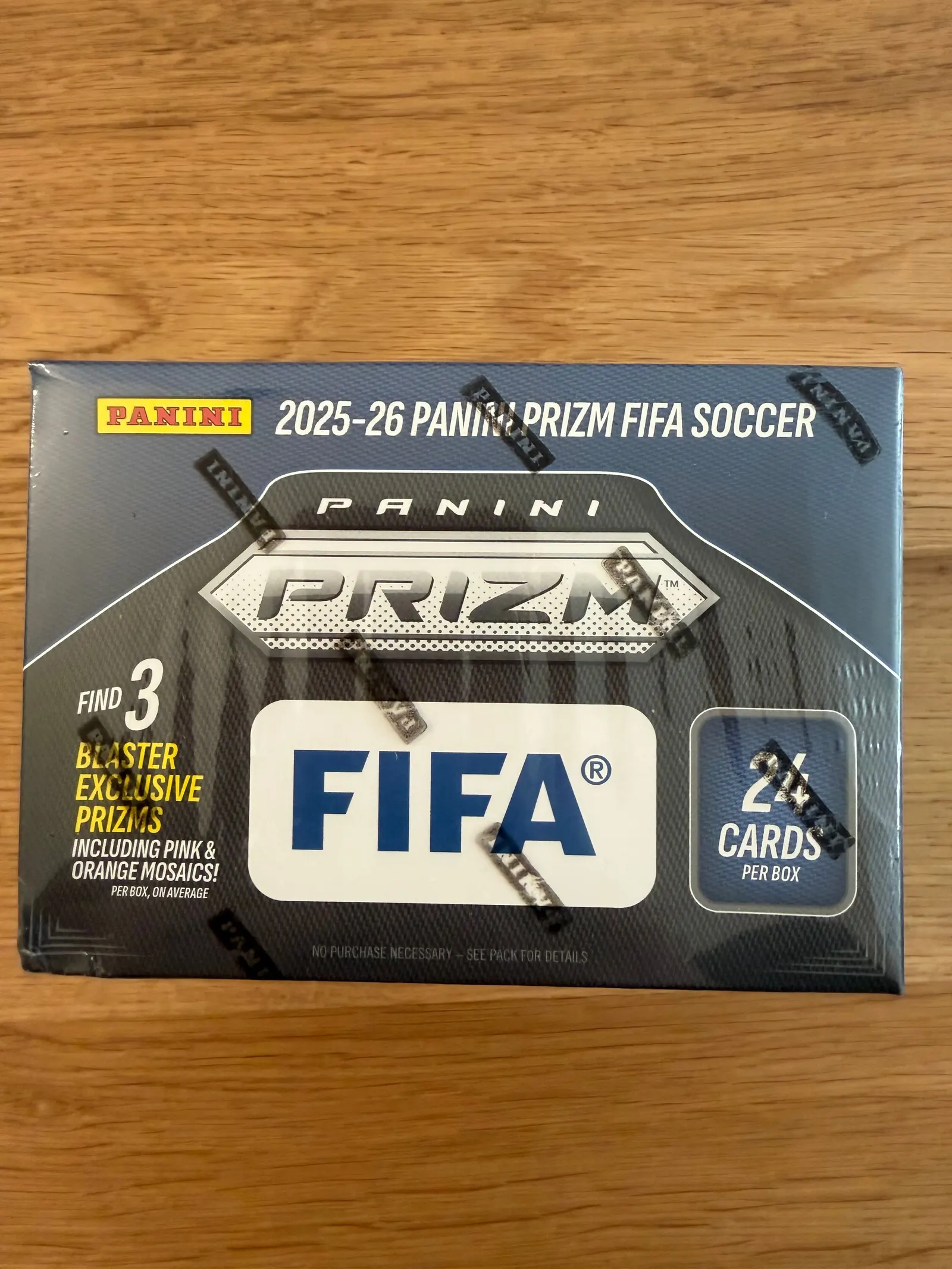 Panini Prizm FIFA Soccer 2025/26, górna ścianka blastera z napisem find 3 blaster exclusive Prizms including Pink & Orange Mosaics i naklejką zabezpieczającą